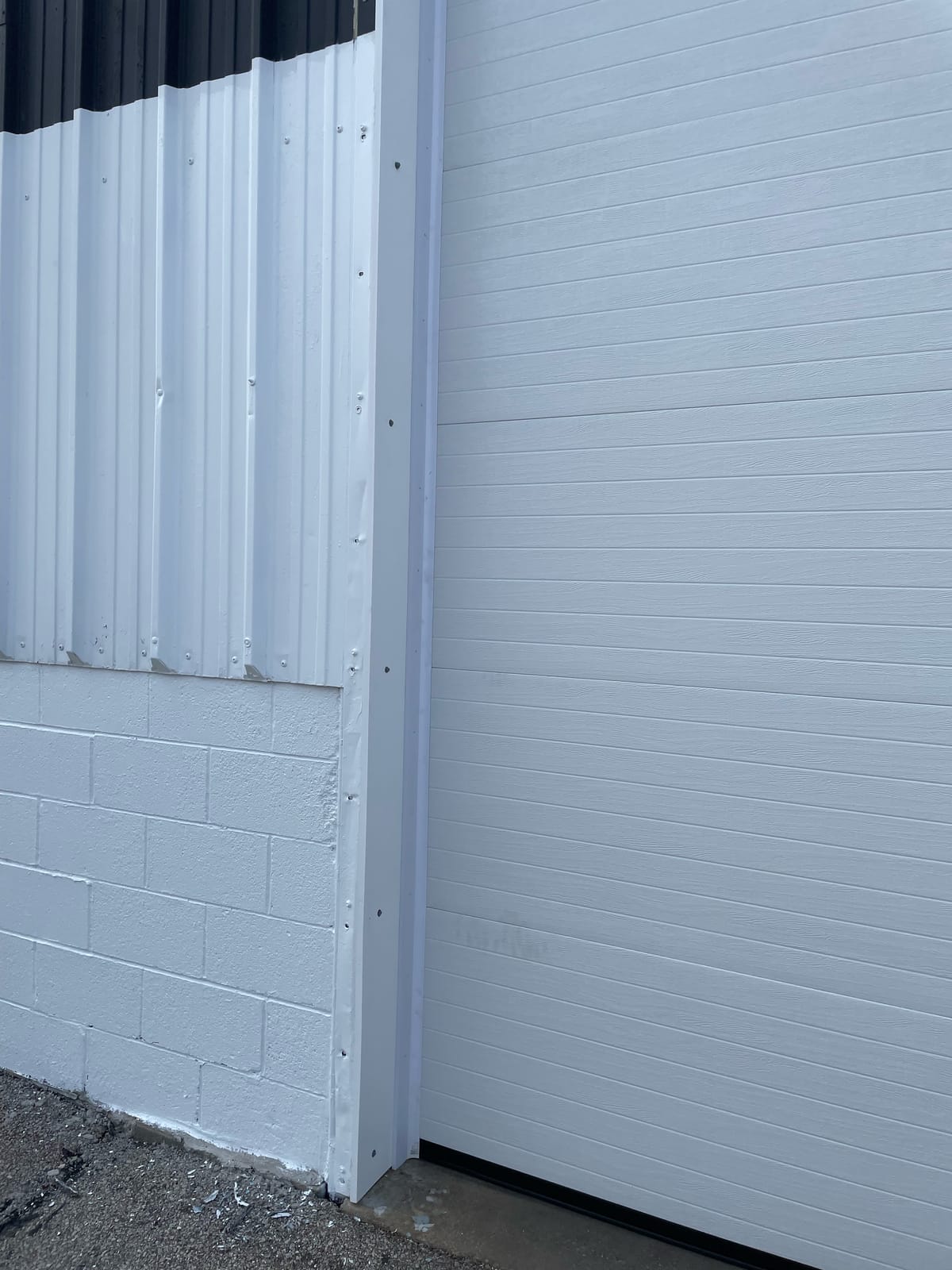 Repainted exterior siding and overhead door at the Buick Lambert dealership, a design-build painting scope in Canton