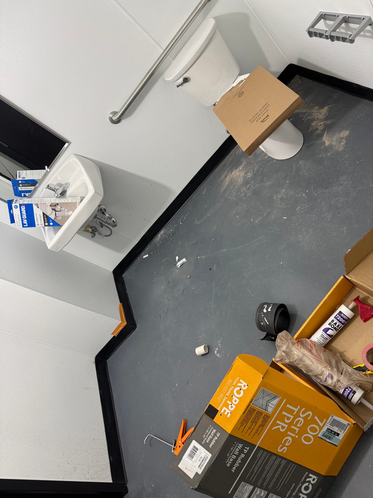 Restroom rough-in with painted wall panels, a toilet, and a sink at a new Dollar General store