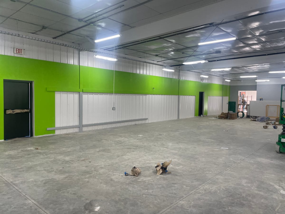 Finished green and white painted sales floor walls at a new Dollar General store, ready for shelving