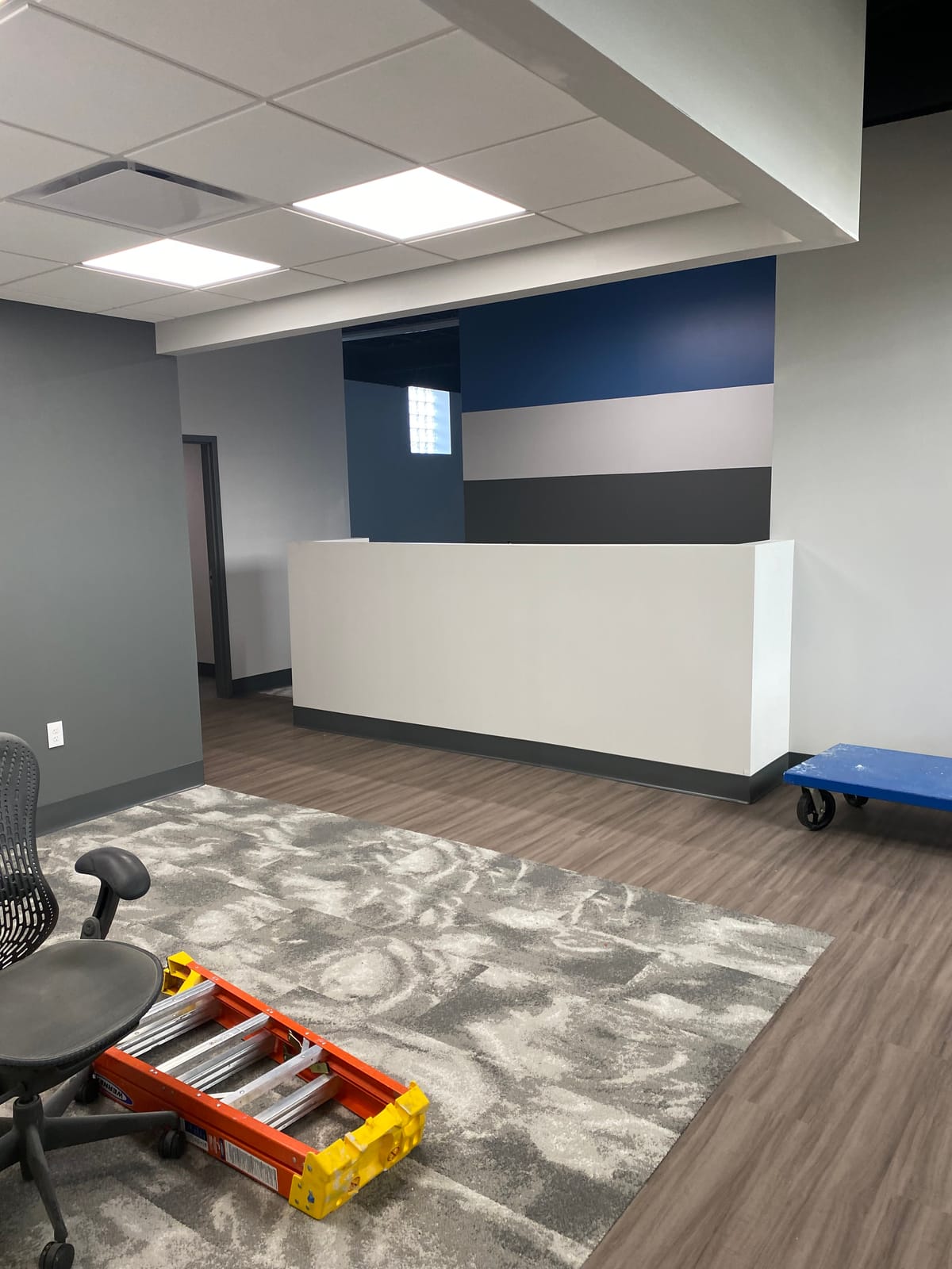 Repainted commercial office reception area with a striped navy and grey accent wall