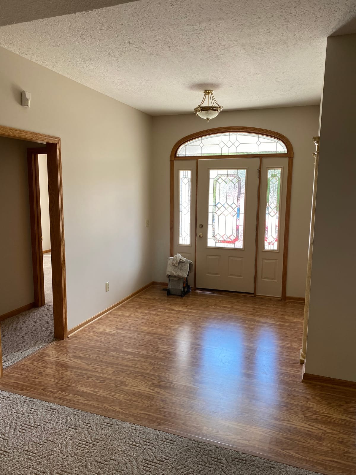 Repainted two-story foyer with an original stained-glass entry door in a Northeast Ohio home