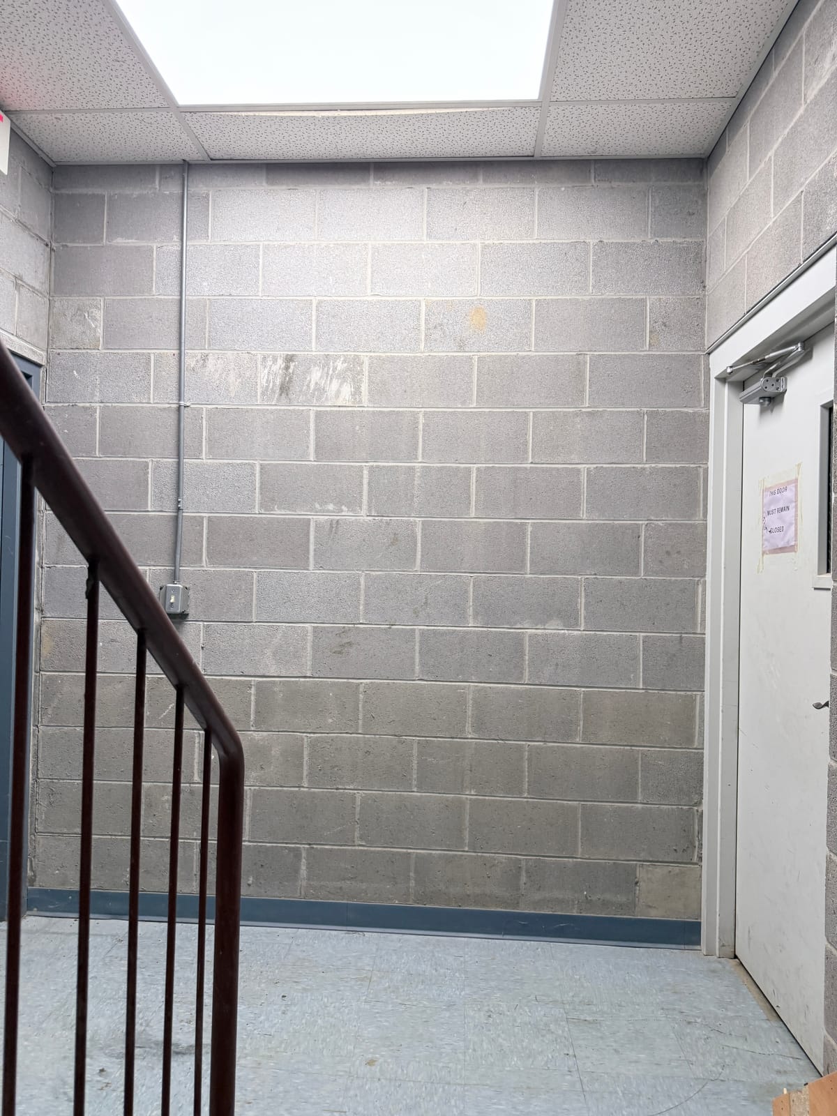 Painted metal wall section and CMU base course on a repainted industrial building exterior