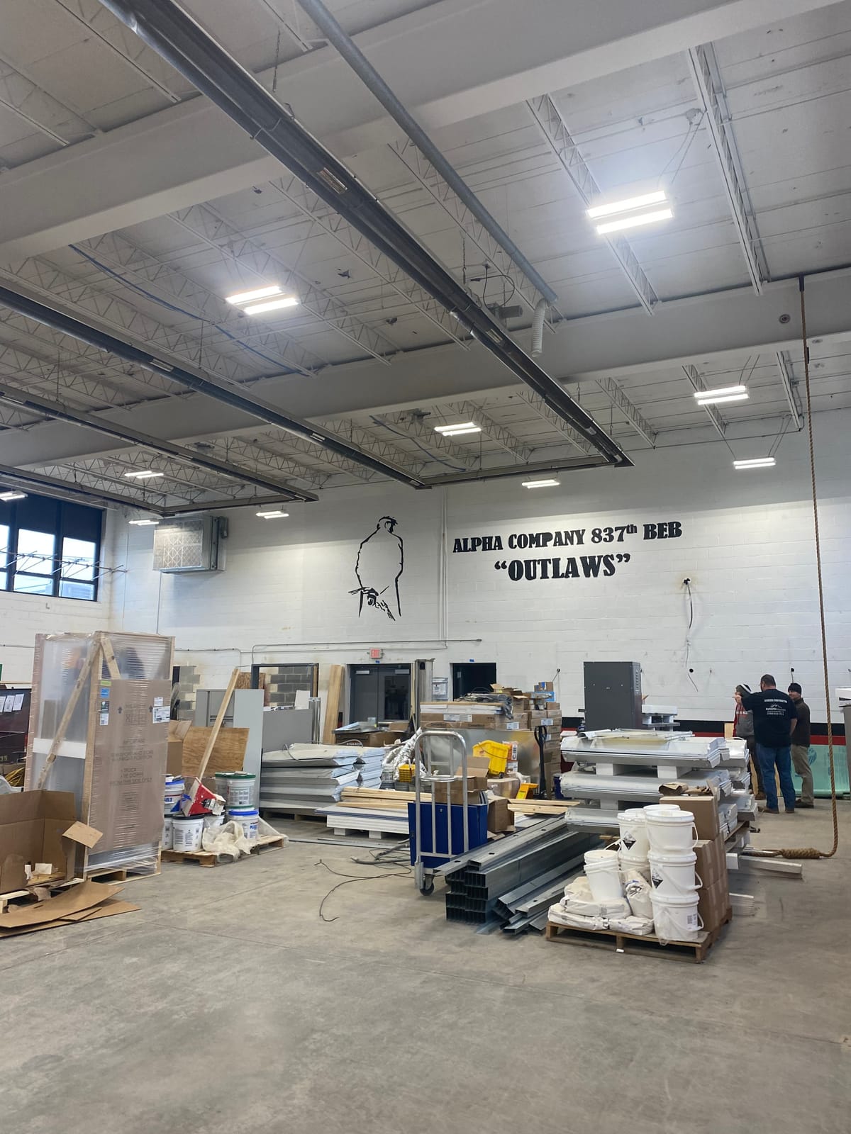 Interior drill hall with painted white CMU block walls at an Ohio Army National Guard armory